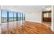 Open bedroom with wood floors and floor-to-ceiling windows overlooking the ocean, with an ensuite bathroom at 7600 Bayshore Dr # 1201A, Treasure Island, FL 33706