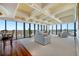 Open living room with waterfront views, white sofas, coffered ceilings, and hardwood floors at 7600 Bayshore Dr # 1201A, Treasure Island, FL 33706