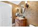 Sophisticated powder room with a custom vanity, stone sink, and decorative mirror and sconces at 7600 Bayshore Dr # 1201A, Treasure Island, FL 33706