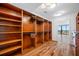 Spacious walk-in closet featuring custom shelving, wooden floors, and access to the balcony with beautiful views at 7600 Bayshore Dr # 1201A, Treasure Island, FL 33706