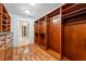 Spacious walk-in closet features custom wood shelving and drawers with hardwood floors at 7600 Bayshore Dr # 1201A, Treasure Island, FL 33706