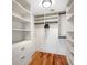 Organized walk-in closet featuring white shelves, drawers, and hanging rods, maximizing storage space at 7600 Bayshore Dr # 1201A, Treasure Island, FL 33706