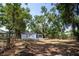 View of the backyard with a home and trees, with two white chairs on a concrete patio at 8059 26Th N Ave, St Petersburg, FL 33710