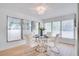 Sunlit dining area features a glass table with chrome base and four modern white chairs at 8059 26Th N Ave, St Petersburg, FL 33710