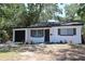 Charming home featuring a black garage door, complemented by white paint, black trim and a well-manicured lawn at 8059 26Th N Ave, St Petersburg, FL 33710