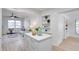 Bright kitchen island with quartz countertop and white cabinets open to the light-filled living area at 8059 26Th N Ave, St Petersburg, FL 33710