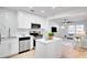 Modern kitchen with island, stainless appliances, white cabinets and countertops open to the living area at 8059 26Th N Ave, St Petersburg, FL 33710