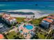 Stunning aerial view of the community showcasing the pool, beachfront access, and well-maintained green spaces at 865 S Gulfview Blvd # 202, Clearwater Beach, FL 33767