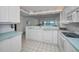 Updated beach view kitchen features white appliances and cabinets, and pass through at 865 S Gulfview Blvd # 202, Clearwater Beach, FL 33767