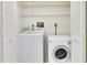 Convenient laundry room featuring a washer, dryer, and shelving, maximizing space within the home at 9000 Commodore Dr # 606, Seminole, FL 33776
