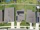 Overhead view of homes with solar panels, green lawns, and a neighborhood street at 9293 Rally Spring Loop, Wesley Chapel, FL 33545