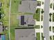 Drone shot of houses featuring solar panels on their roofs and expansive green lawns at 9293 Rally Spring Loop, Wesley Chapel, FL 33545