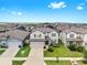 Two-story home with gray siding, a well-kept lawn, and neatly trimmed landscaping at 9293 Rally Spring Loop, Wesley Chapel, FL 33545