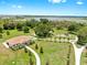 Aerial view features a single-story building surrounded by lush landscape, walking path, playground, & lake views at 9293 Rally Spring Loop, Wesley Chapel, FL 33545
