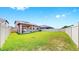 Lush backyard featuring a pristine lawn, enclosed by a white vinyl fence for added privacy at 9293 Rally Spring Loop, Wesley Chapel, FL 33545