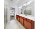 Bright bathroom featuring double sinks, vanity and glass enclosed shower at 9293 Rally Spring Loop, Wesley Chapel, FL 33545