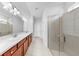 Bathroom featuring double sinks, spacious vanity, and glass enclosed shower at 9293 Rally Spring Loop, Wesley Chapel, FL 33545