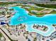 Fantastic aerial view showcases a Gathering-friendly community pool with waterslides, sandy beach, and cabanas at 9293 Rally Spring Loop, Wesley Chapel, FL 33545