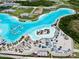 An impressive aerial view of the community pool featuring a sandy beach, lounge chairs, and palm trees at 9293 Rally Spring Loop, Wesley Chapel, FL 33545