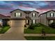Charming two-story home featuring a two-car garage, manicured lawn, and beautiful landscaping at 9293 Rally Spring Loop, Wesley Chapel, FL 33545