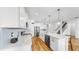 Bright, modern kitchen features white cabinets, stainless steel appliances, and beautiful pendant lights at 9293 Rally Spring Loop, Wesley Chapel, FL 33545