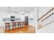 Modern kitchen boasts stainless steel appliances, white cabinets, a central island, and adjacent staircase, offering functionality and style at 9293 Rally Spring Loop, Wesley Chapel, FL 33545