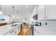 Bright, modern kitchen with white cabinets, stainless appliances, and a spacious island flowing into the living and dining areas at 9293 Rally Spring Loop, Wesley Chapel, FL 33545