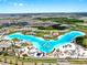 Aerial of the lagoon community featuring a waterpark and the crystal lagoon providing a retreat for residents at 9293 Rally Spring Loop, Wesley Chapel, FL 33545