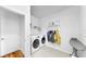 Clean laundry room featuring a washer, dryer, storage shelves, and a coat rack at 9293 Rally Spring Loop, Wesley Chapel, FL 33545