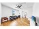 Open living space with hardwood floors, sofa, and television at 9293 Rally Spring Loop, Wesley Chapel, FL 33545