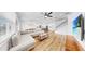 Open-concept living room showcases a large sectional sofa, hardwood floors, and seamless transitions to the kitchen and staircase at 9293 Rally Spring Loop, Wesley Chapel, FL 33545
