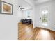 Open living space with hardwood floors, sofa, and front door at 9293 Rally Spring Loop, Wesley Chapel, FL 33545