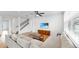 Bright living room with hardwood floors, large sectional sofa, staircase, and a wall-mounted television for comfortable living at 9293 Rally Spring Loop, Wesley Chapel, FL 33545