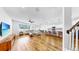 Spacious open-concept living area with hardwood flooring, leading to a well-appointed kitchen and adjacent staircase at 9293 Rally Spring Loop, Wesley Chapel, FL 33545
