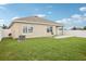 Backyard featuring lush green grass, a concrete patio, and a partial view of a white fence at 10233 Opaline Sky Pl, Riverview, FL 33578