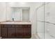 Bathroom featuring double sinks, dark wood cabinets, and a glass-enclosed shower at 10233 Opaline Sky Pl, Riverview, FL 33578