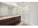 Bathroom with double sinks, dark wood cabinets, and a glass-enclosed shower at 10233 Opaline Sky Pl, Riverview, FL 33578