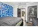 Cozy bedroom featuring a unique blue accent wall and dark wood floors at 10233 Opaline Sky Pl, Riverview, FL 33578