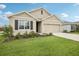 Charming single-story home featuring a well-manicured lawn, neutral stucco, and a two-car garage at 10233 Opaline Sky Pl, Riverview, FL 33578