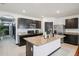 Bright kitchen with dark cabinets, stainless appliances, and an island with granite countertops at 10233 Opaline Sky Pl, Riverview, FL 33578