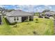 Aerial view of the backyard with a screened lanai, landscaping, and a well-maintained lawn at 10381 Tupper Cay Dr, San Antonio, FL 33576