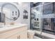 Elegant bathroom with a stylish vanity, decorative mirror, and glass-enclosed shower with blue-toned tiling at 10381 Tupper Cay Dr, San Antonio, FL 33576
