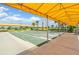 Bocce ball courts with yellow sunshades, lush landscaping, and blue skies at 10381 Tupper Cay Dr, San Antonio, FL 33576