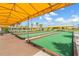Bocce ball courts with yellow sunshades, lush landscaping, and blue skies at 10381 Tupper Cay Dr, San Antonio, FL 33576
