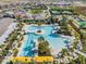 Aerial shot of a large community pool and recreation area surrounded by palm trees and lounge chairs at 10381 Tupper Cay Dr, San Antonio, FL 33576