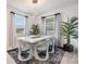 Bright dining room featuring a modern white table, unique chairs, pendant lighting, and stylish rug at 10381 Tupper Cay Dr, San Antonio, FL 33576