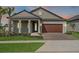 Charming single-story home featuring a two-car garage, well-manicured lawn, and inviting front porch at 10381 Tupper Cay Dr, San Antonio, FL 33576