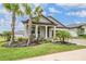 Attractive home with well-maintained landscaping, mature palm trees, and inviting front porch at 10381 Tupper Cay Dr, San Antonio, FL 33576