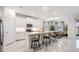 Modern kitchen with marble floors, an island with bar stools, white cabinetry, and stainless steel appliances at 10381 Tupper Cay Dr, San Antonio, FL 33576