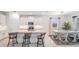 Modern kitchen with a central island, stylish bar stools, and an open dining area with a bright and inviting atmosphere at 10381 Tupper Cay Dr, San Antonio, FL 33576